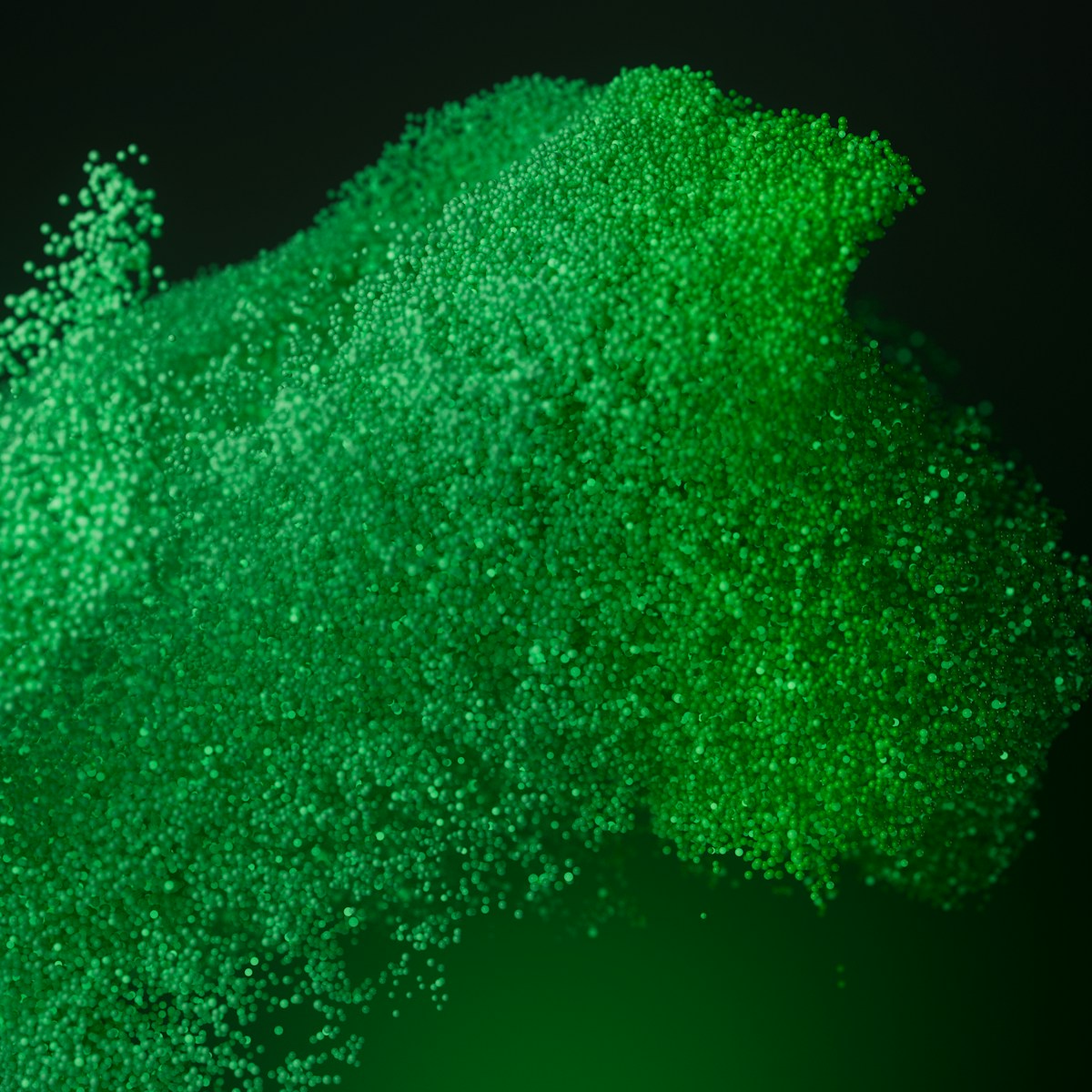 Green particles swirl and create a textured cloud.